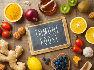 The image shows a small chalkboard with the words "IMMUNE BOOST," surrounded by healthy foods like fruits, vegetables, nuts, and honey.